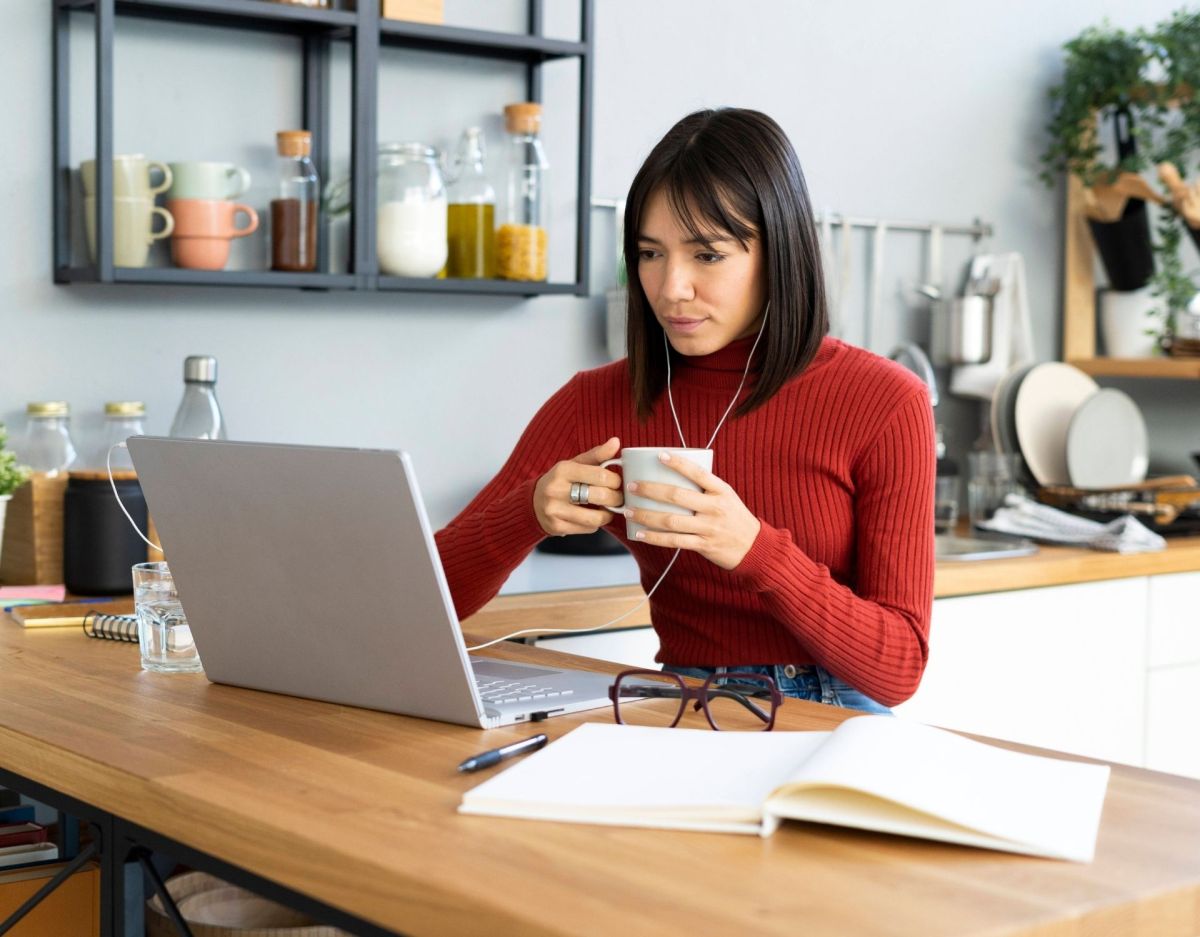 Frau im Home Office vor dem Laptop mit Teetasse