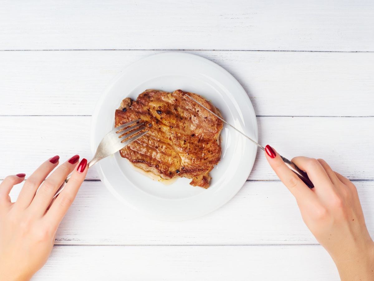 Frau, die Fleisch schneidet