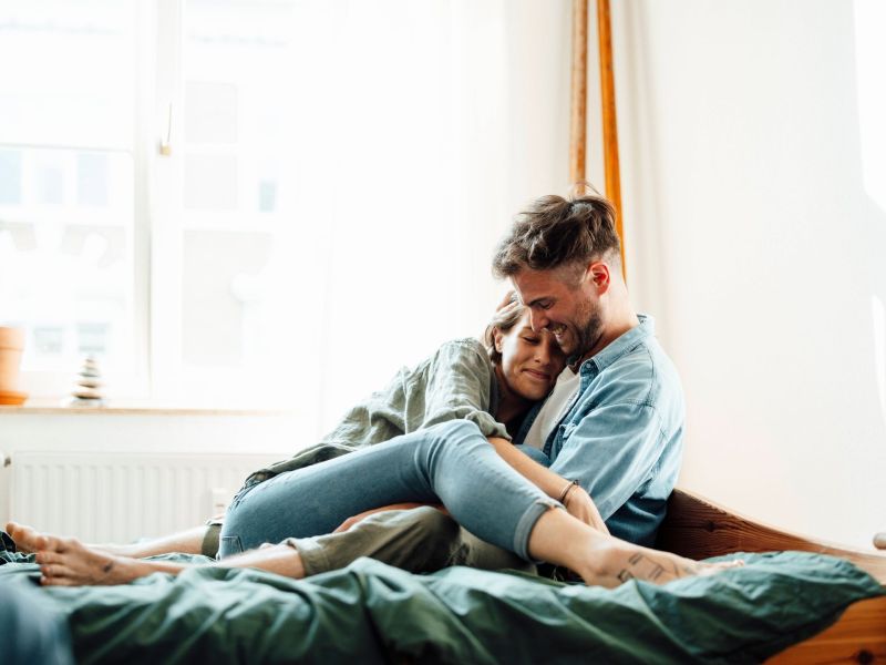 Frau und Mann kuscheln auf dem Bett