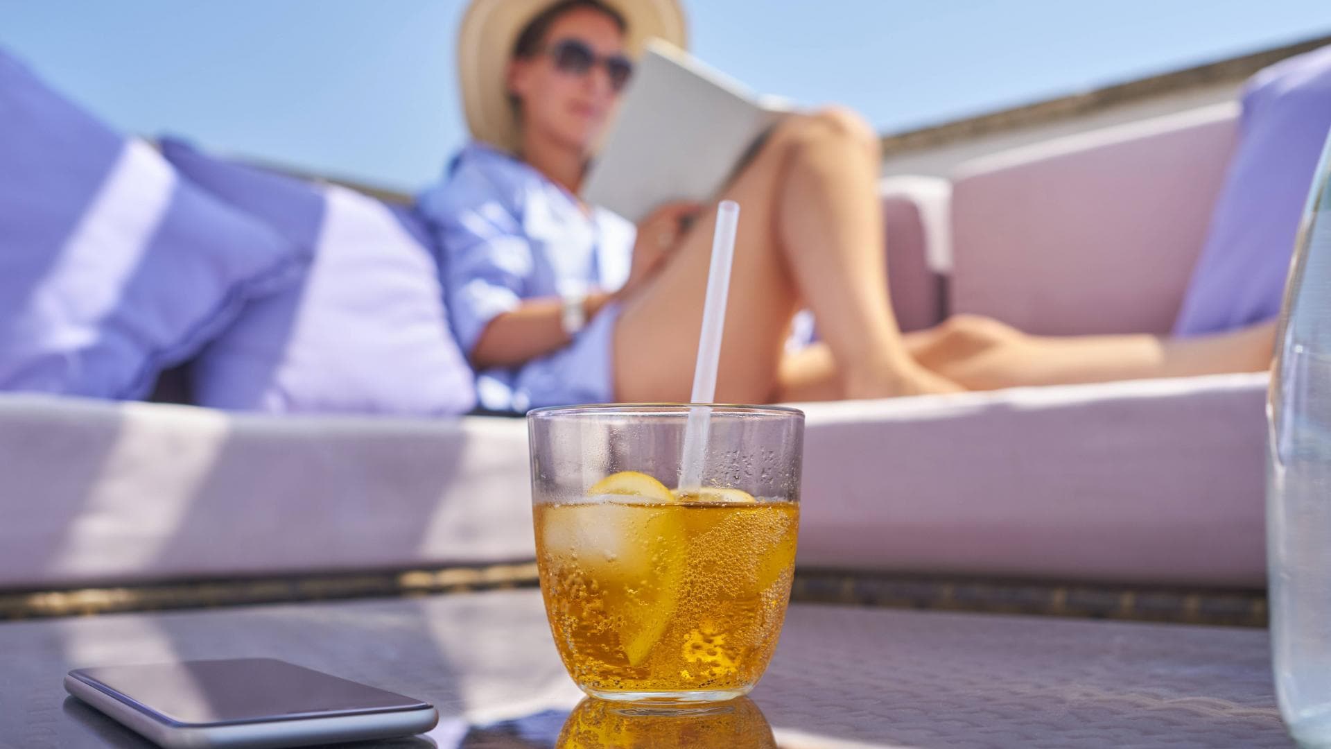 Frau sitzt am Pool mit einem Buch un Digital detox