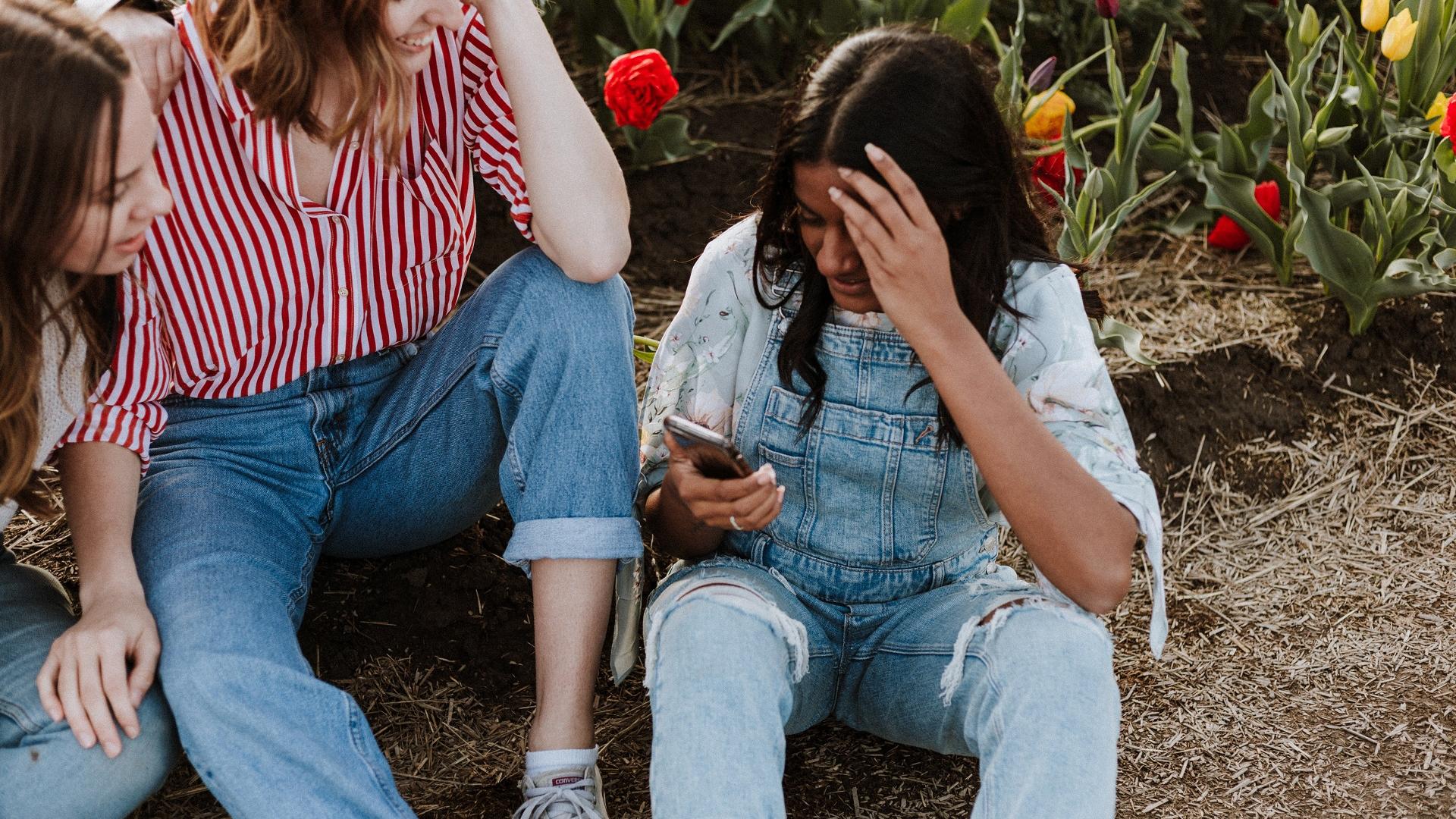 Tinder Tipps richtig anschreiben: Mädchen sitzen zusammen und lachen