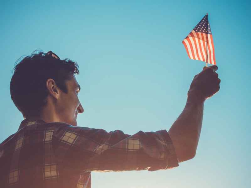 mann hält eine usa flagge in die luft