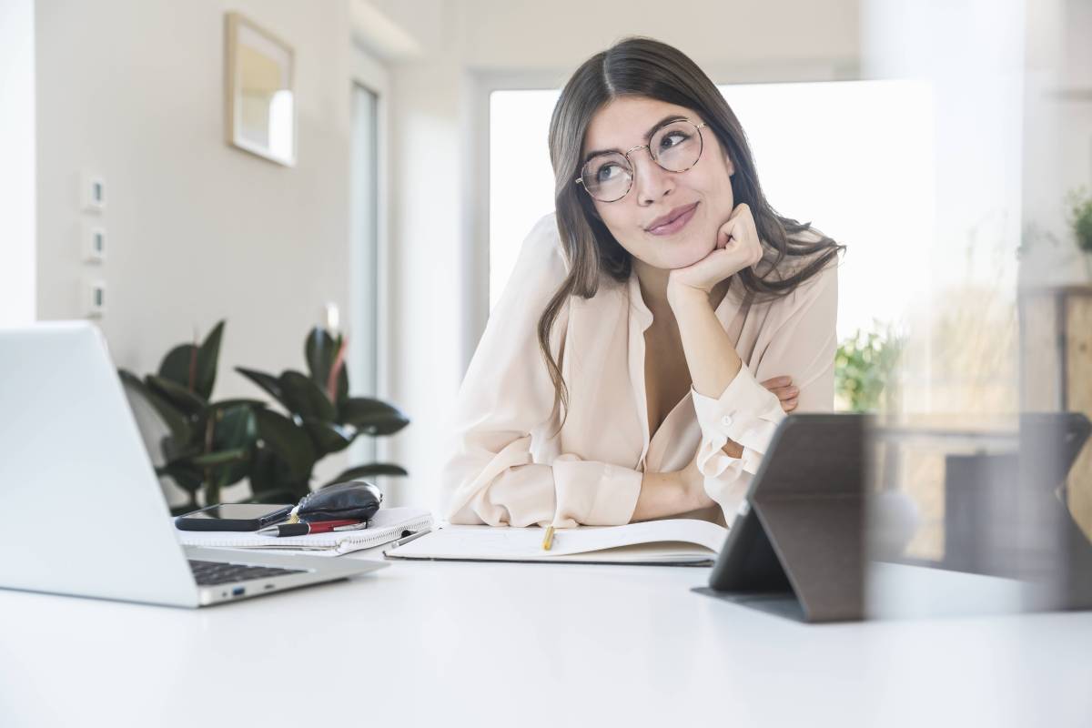 Frau sitzt lächelnd vor Computer