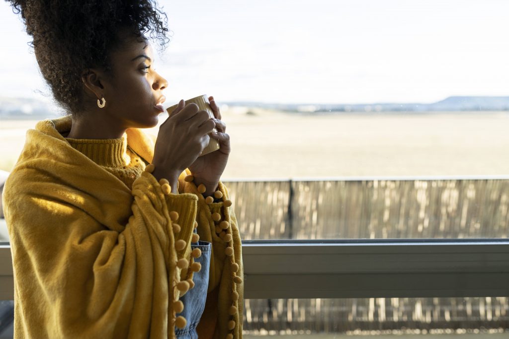 Frau mit Kaffeetasse auf Balkon