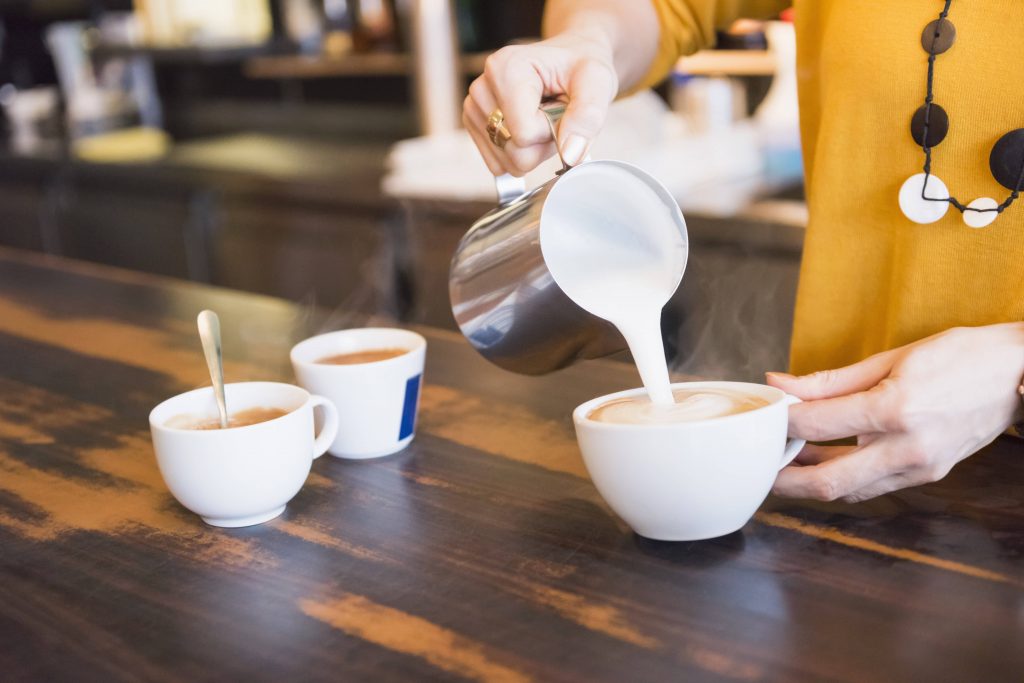 Frau macht Milchschaum