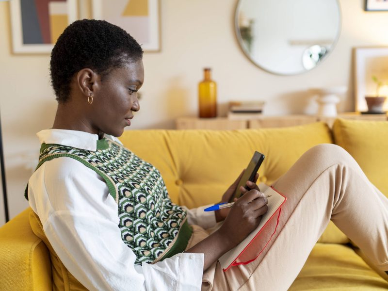 Frau am Handy auf dem Sofa