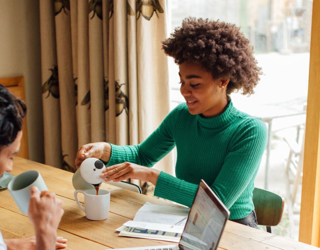 Frau schenkt sich Kaffee ein