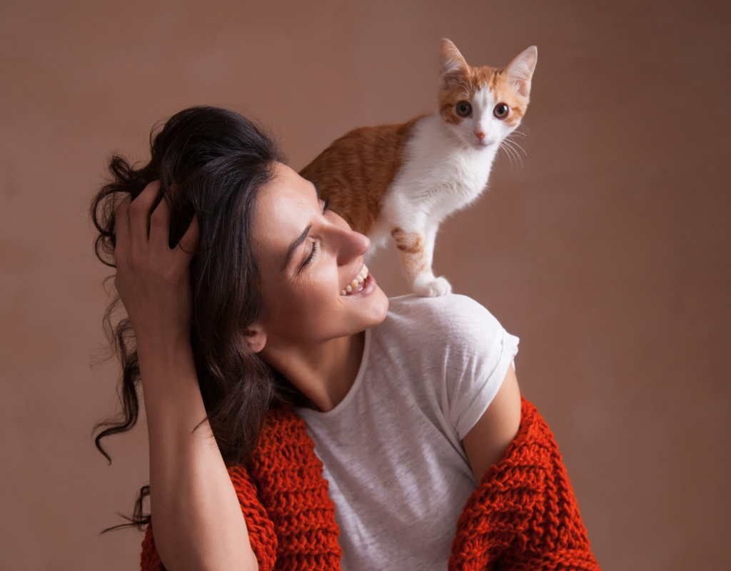 Katze sitzt auf den Schultern einer Frau.