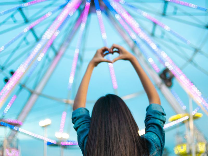 Frau steht vor Riesenrad