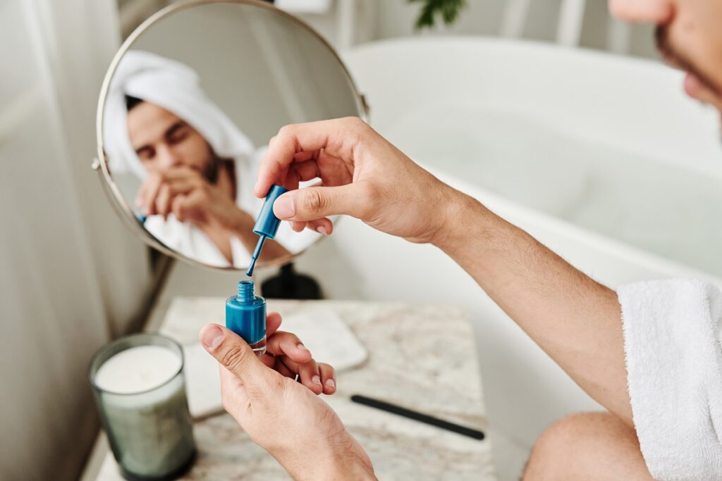 Mann trägt blauen Nagellack auf