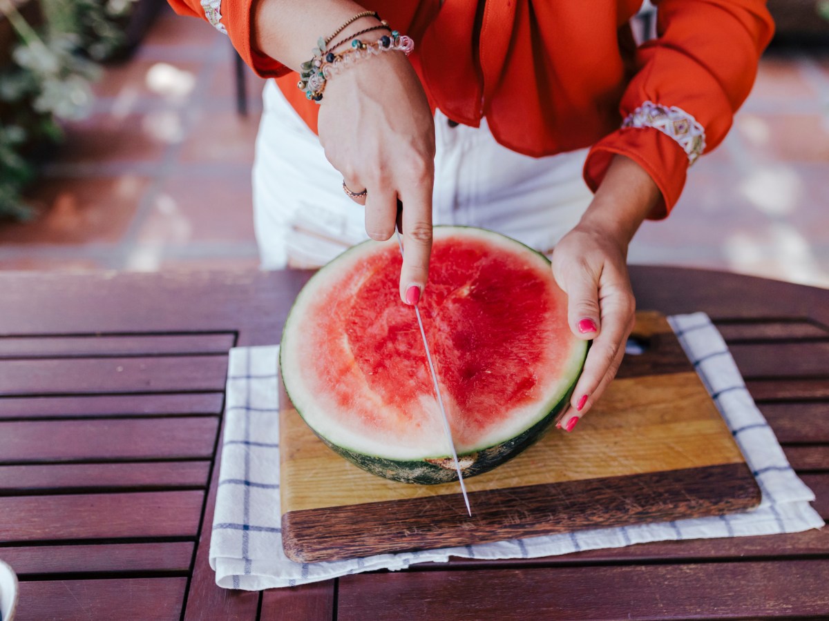 Frau schneidet Melone