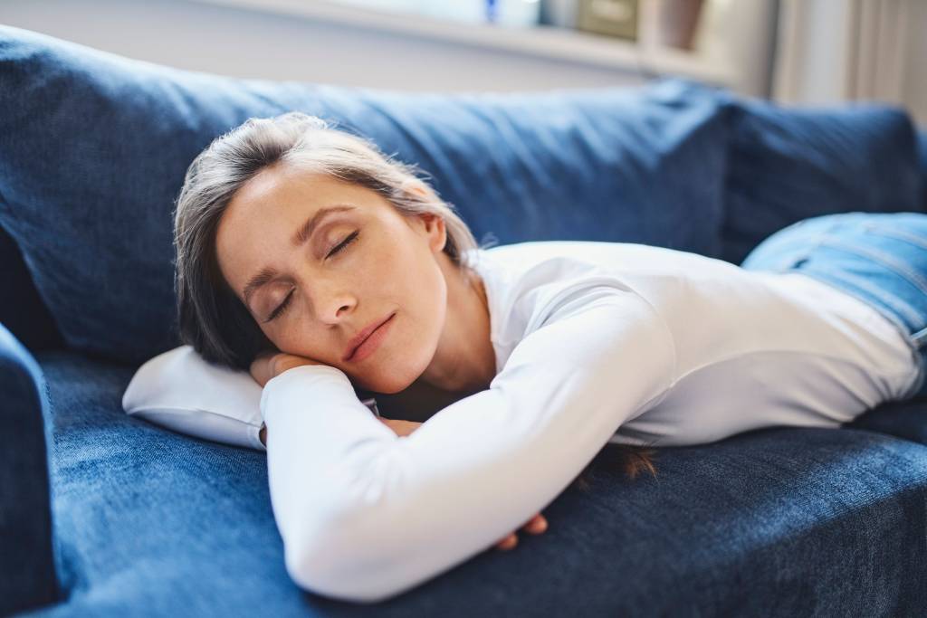 Frau schläft auf Couch