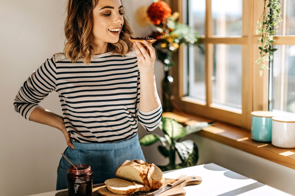 Frau beißt in Marmeladenbrötchen