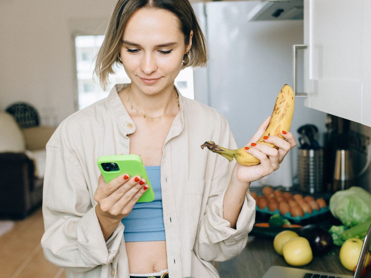 Frau mit Handy und Einkäufen