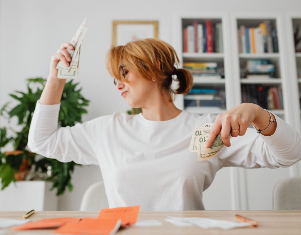 Frau tanzt mit Geld