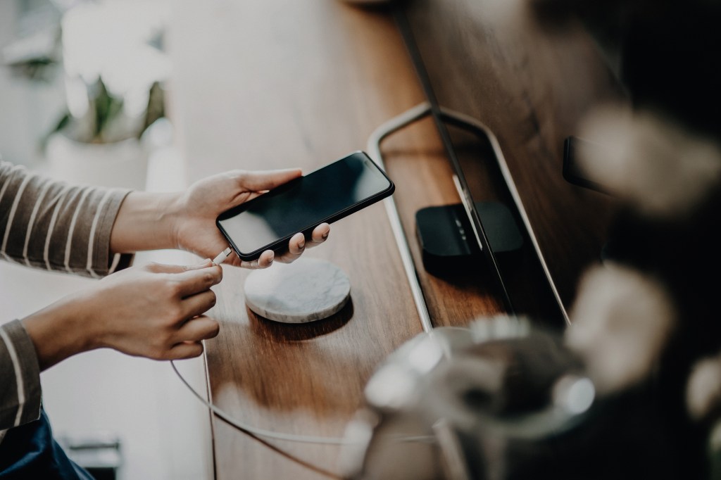 Frau lädt Handy auf