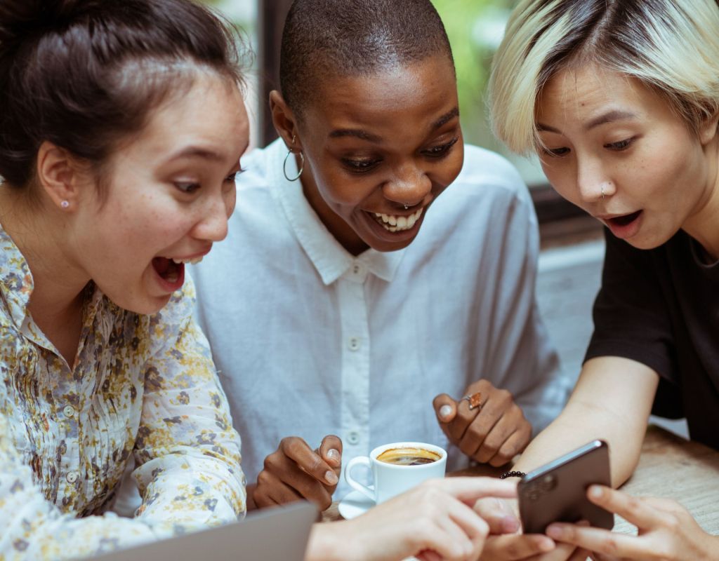 Drei Frauen schauen aufs Handy