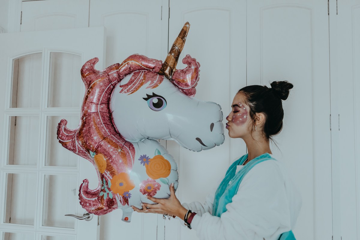 Frau mit Luftballon als Einhorn.