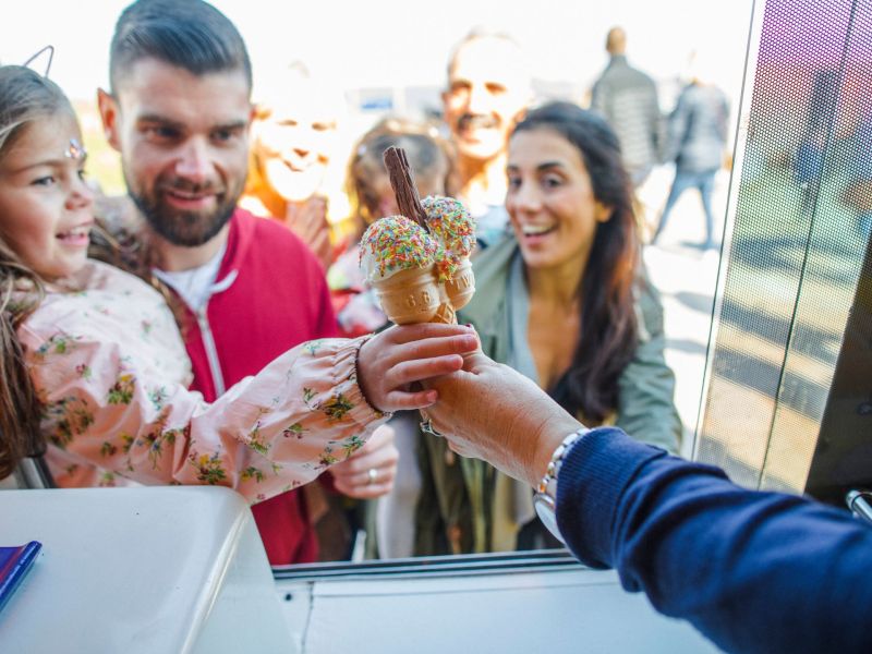 Kind bekommt Eis mit Streuseln