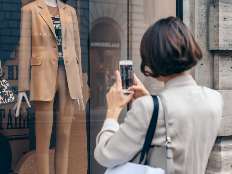 Frau fotografiert ein Schaufenster