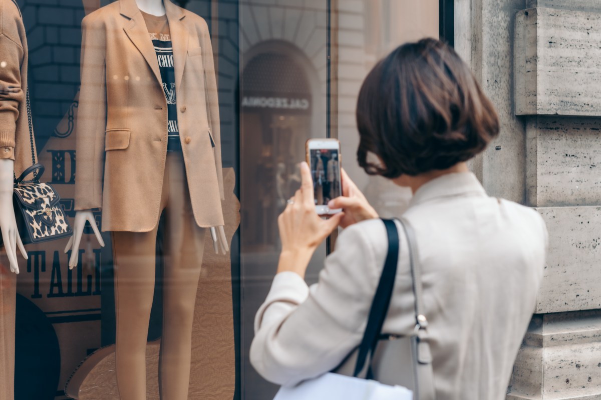 Frau fotografiert ein Schaufenster