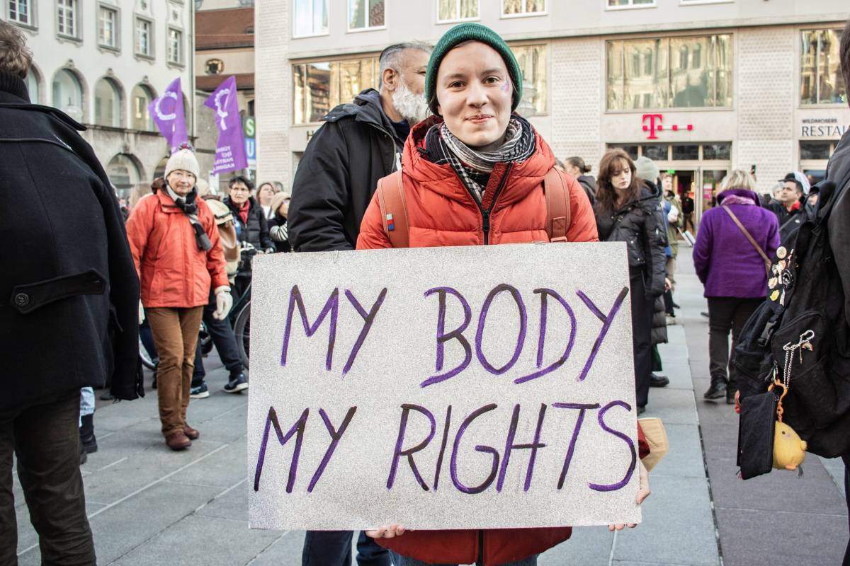 Eine Frau mit feministischem Schild.