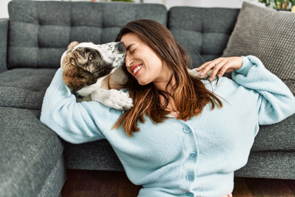 Hund kuschelt mit Frau