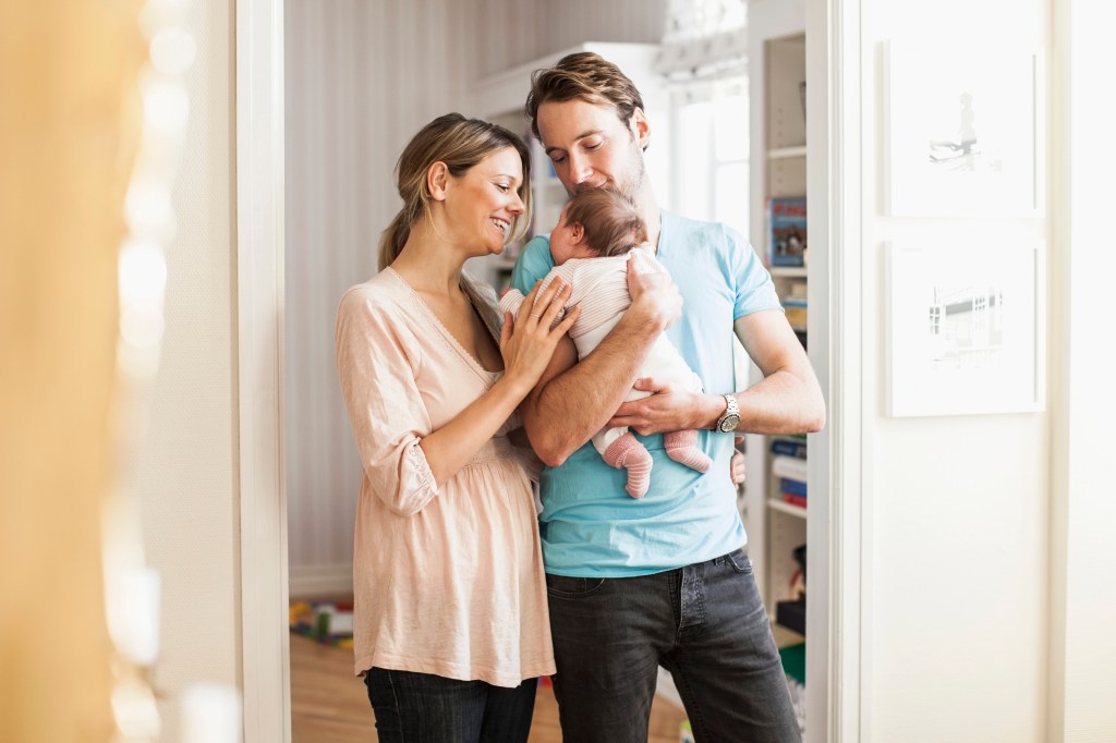 Eine Frau und ein Mann zusammen mit einem neugeborenem Baby.