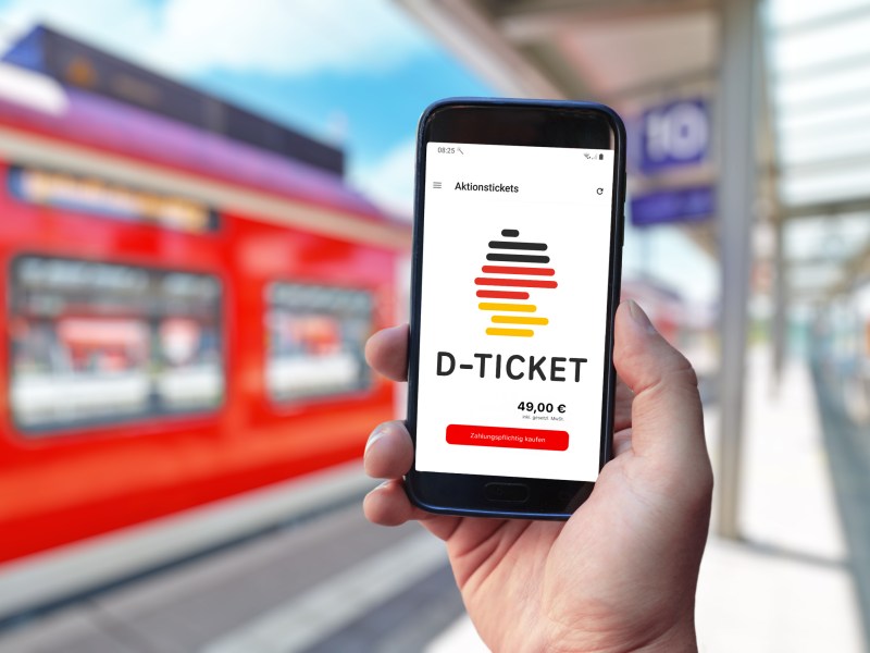 Person hat das Deutschlandticket auf seinem Handy.