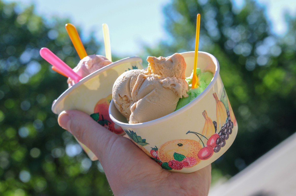 Eine Person hält zwei Becher mit Eis in der Hand.