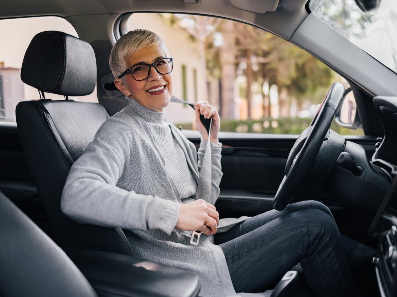 Eine ältere Dame sitzt im Auto.