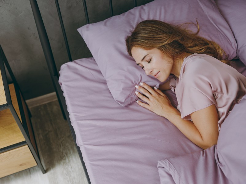 Eine Frau liegt im Bett und schläft.