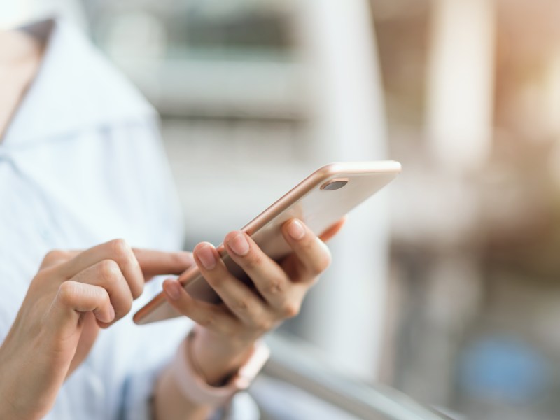 Frau hält ein Handy in der Hand.