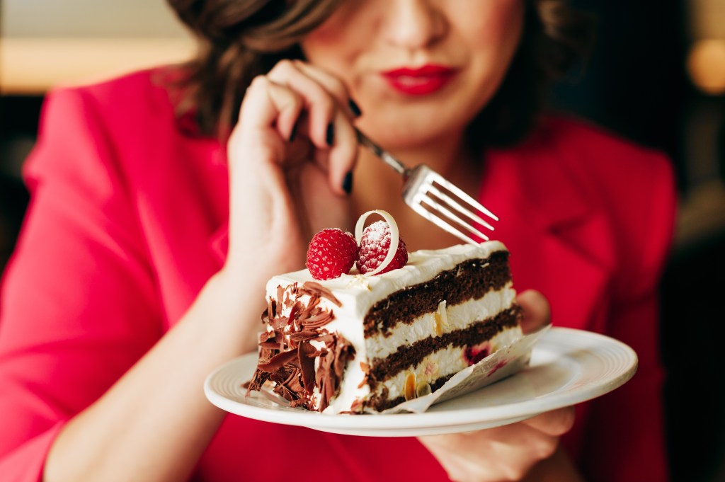 Eine Frau isst Schwarzwälder Kirschtorte