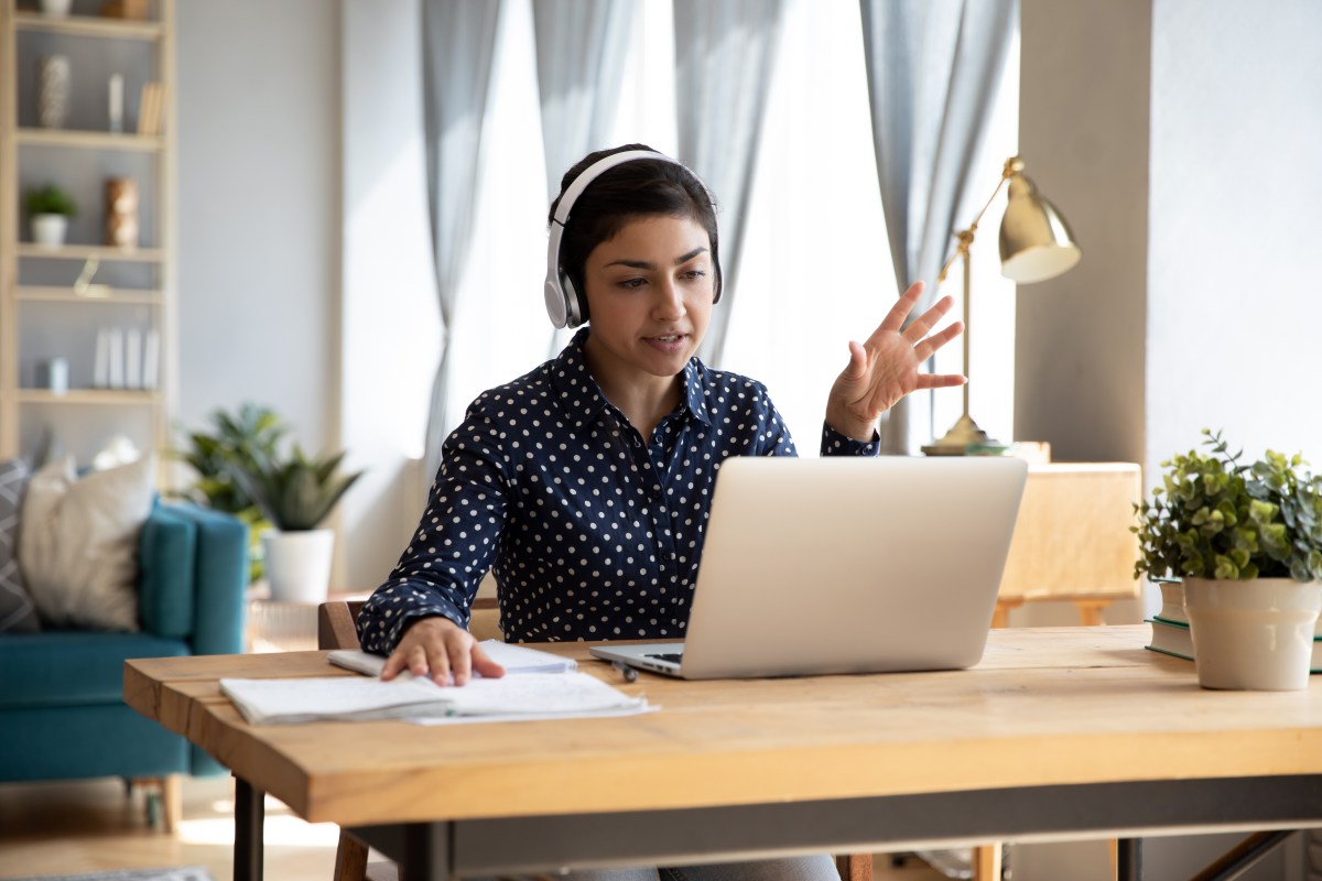 Eine Frau arbeitet im Homeoffice. Sie führt ein Meeting.