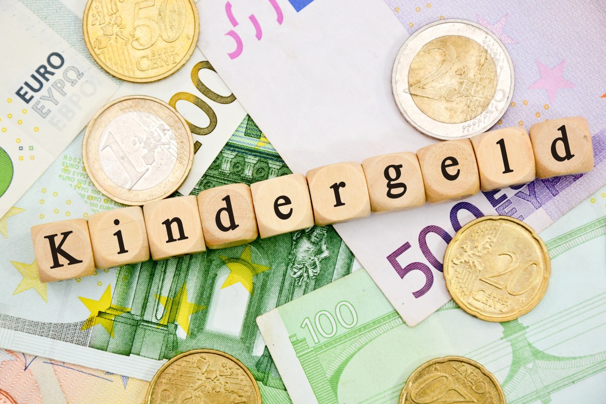 Auf Würfeln steht das Wort "Kindergeld". Darunter liegen Geldscheine.