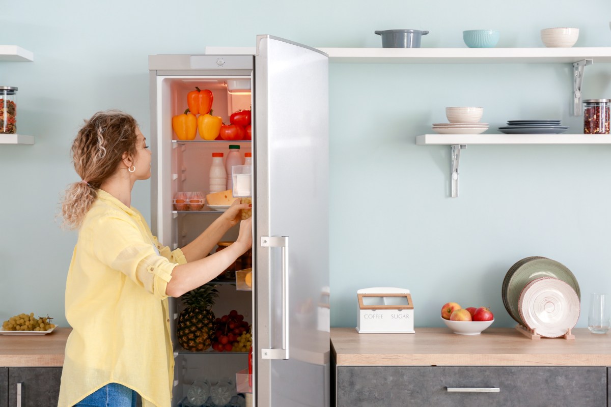 Frau öffnet Kühlschrank