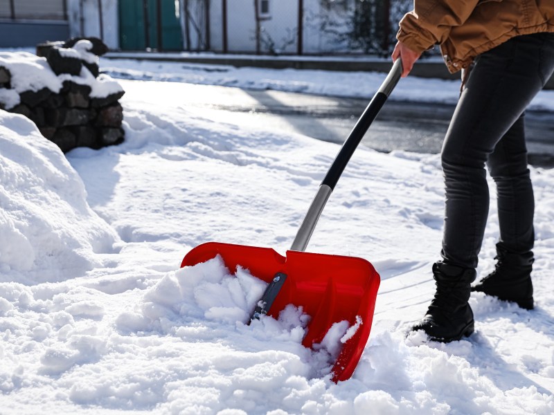 Eine Person schippt Schnee.