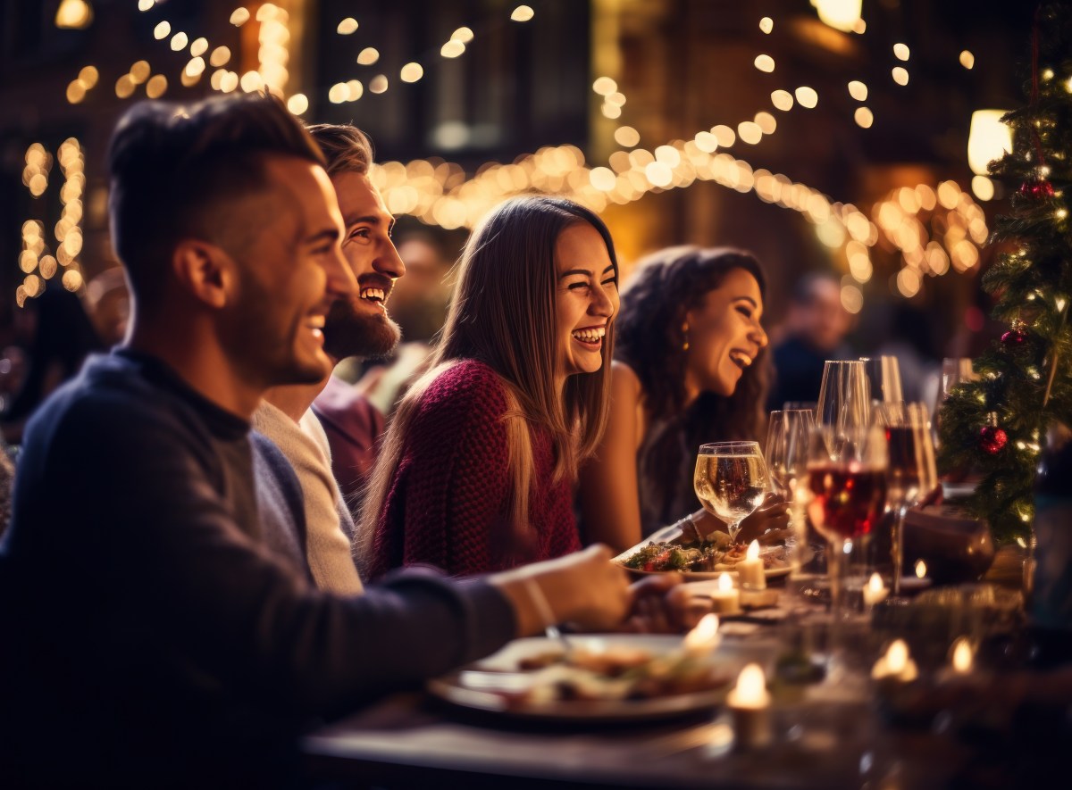 Frauen und Männer sitzen an einem gedeckten Tisch im Restaurant.