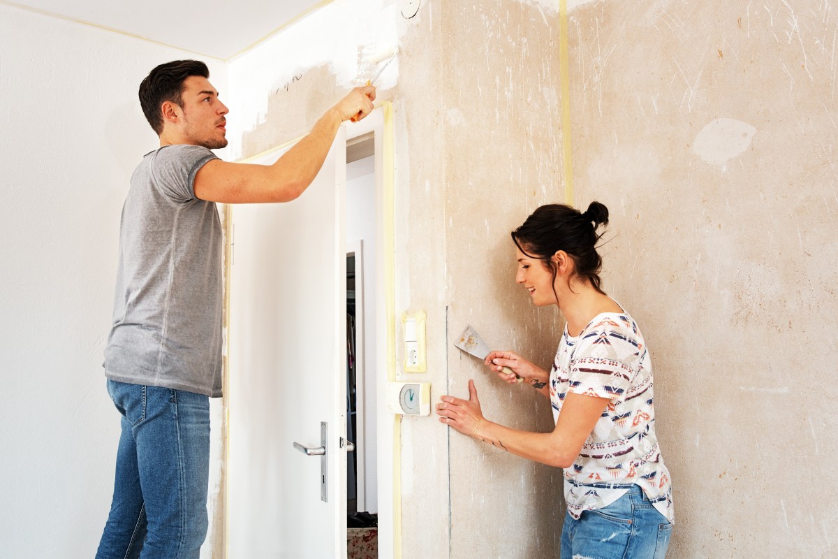 Ein Pärchen streicht gemeinsam eine Wand.