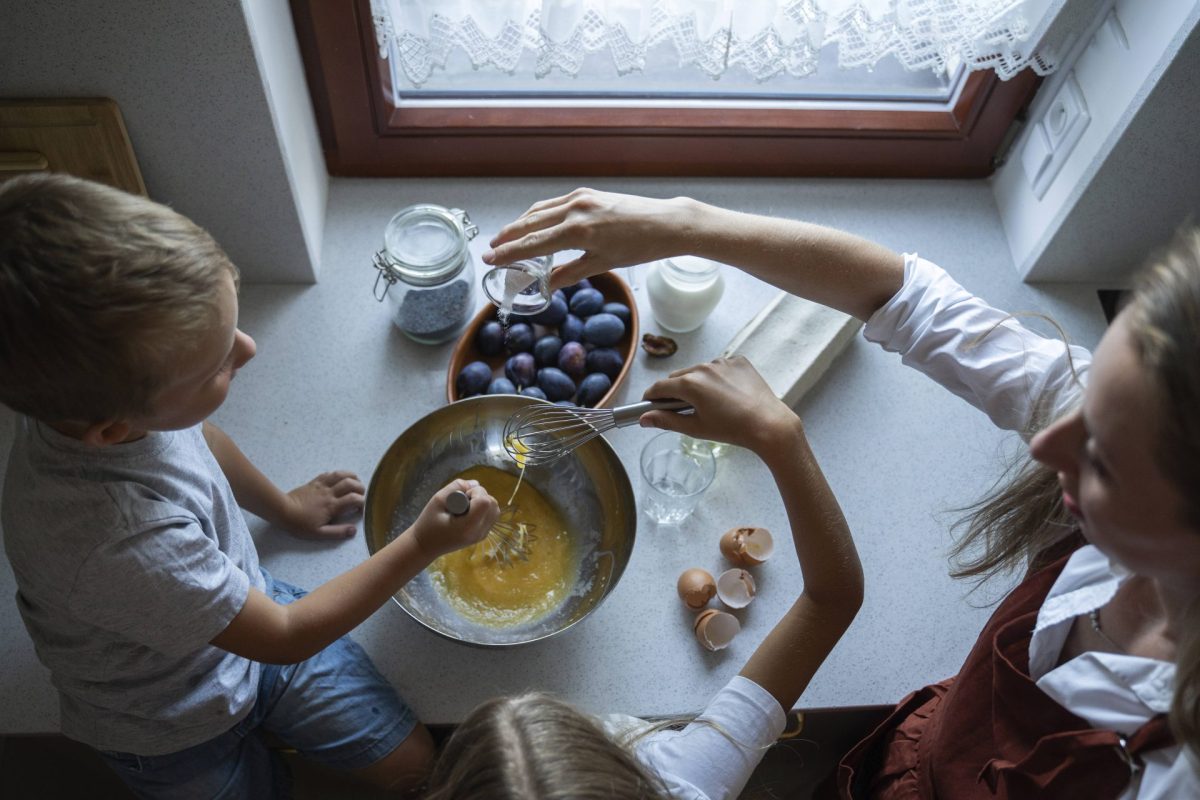 Eine Frau kocht mit ihrem Kind. Sie backen einen Kuchen.