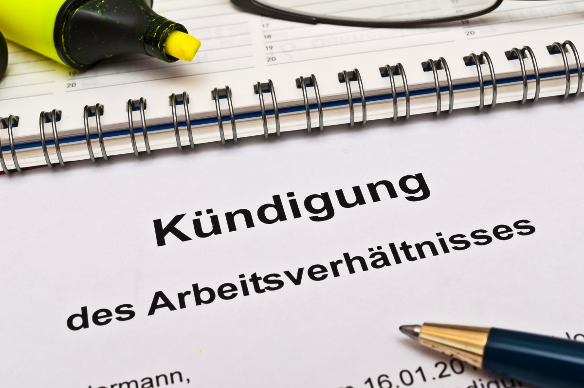 Auf einem Zettel steht geschrieben: "Kündigung des Arbeitsverhältnisses". Daneben liegt ein Kugelschreiber.