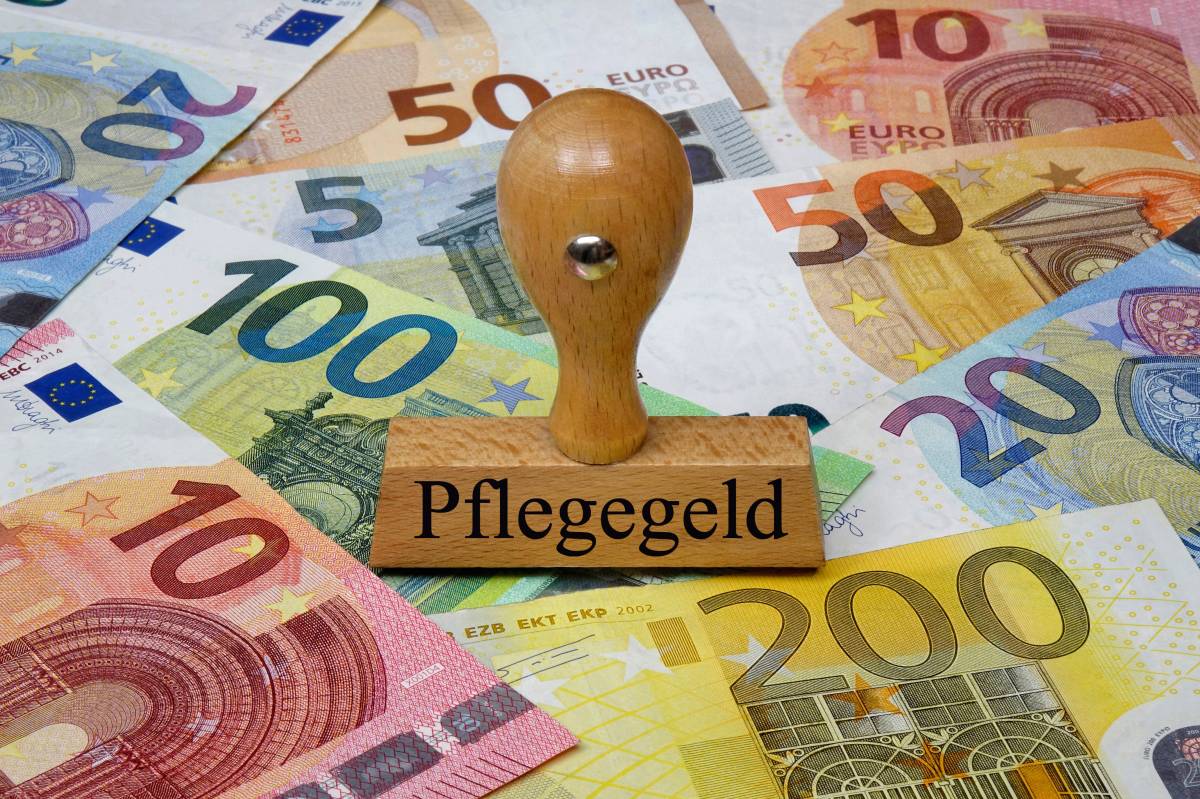 Ein Stempel mit der Aufschrift "Pflegegeld" steht auf Geldscheinen.