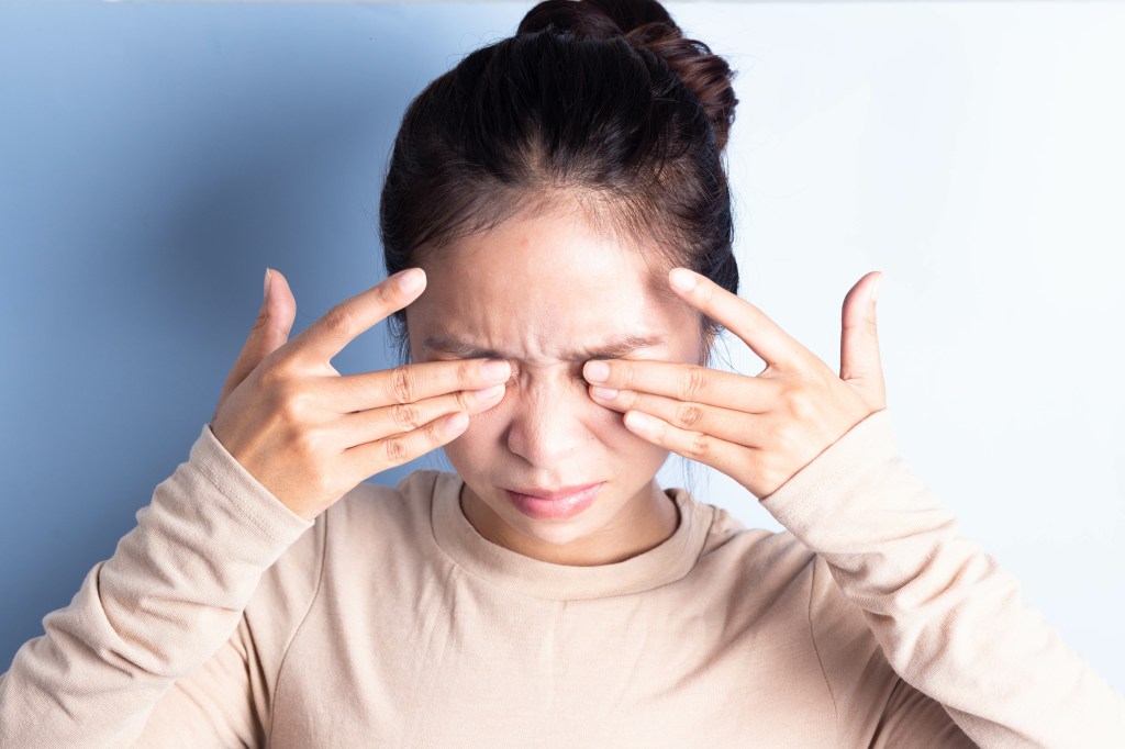 Wimpernverlängerung Allergie Frau reibt sich in den Augen