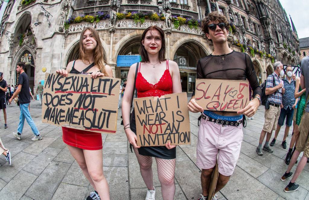 Drei Personen demonstrieren mit Schildern auf dem Marienplatz.