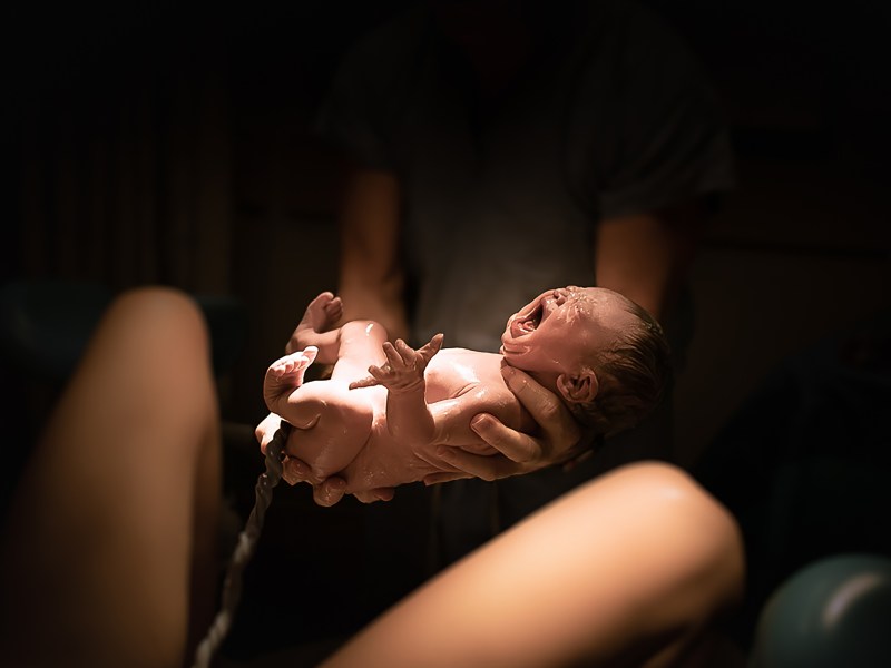 Traumdeutung Geburt Frau hält Baby in den Händen