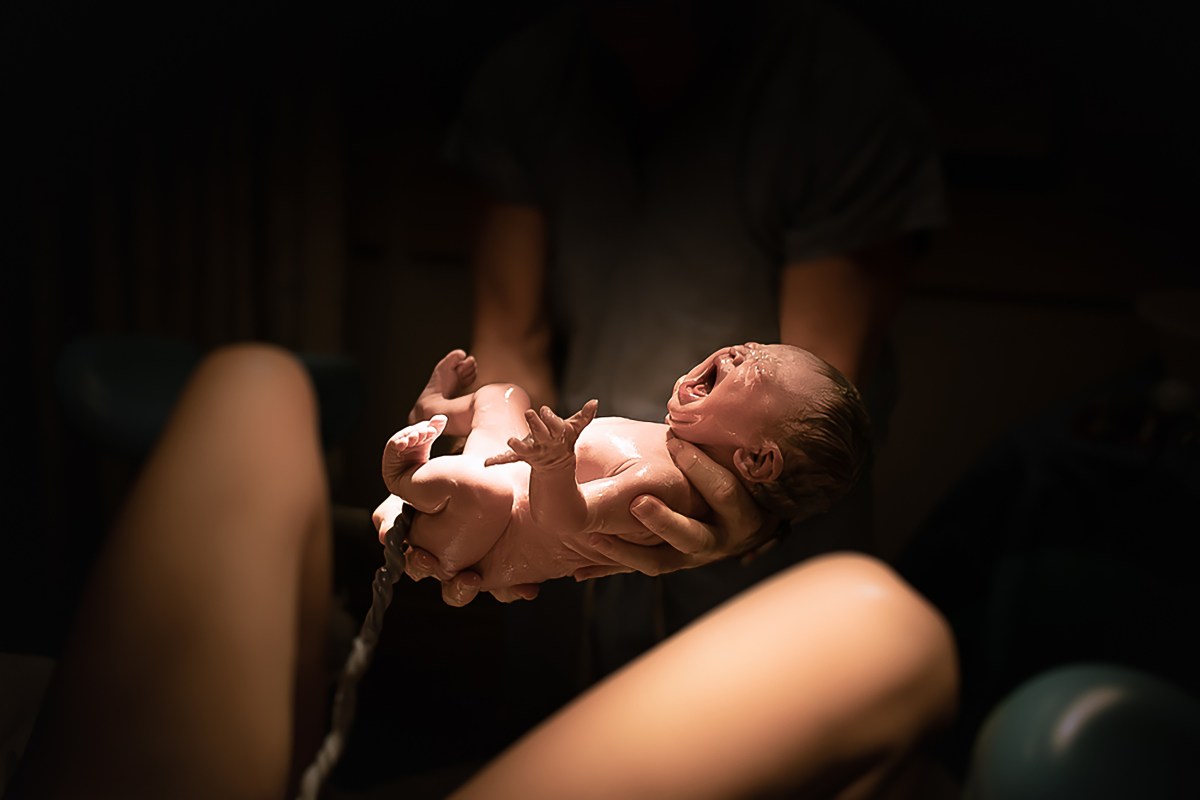 Traumdeutung Geburt Frau hält Baby in den Händen