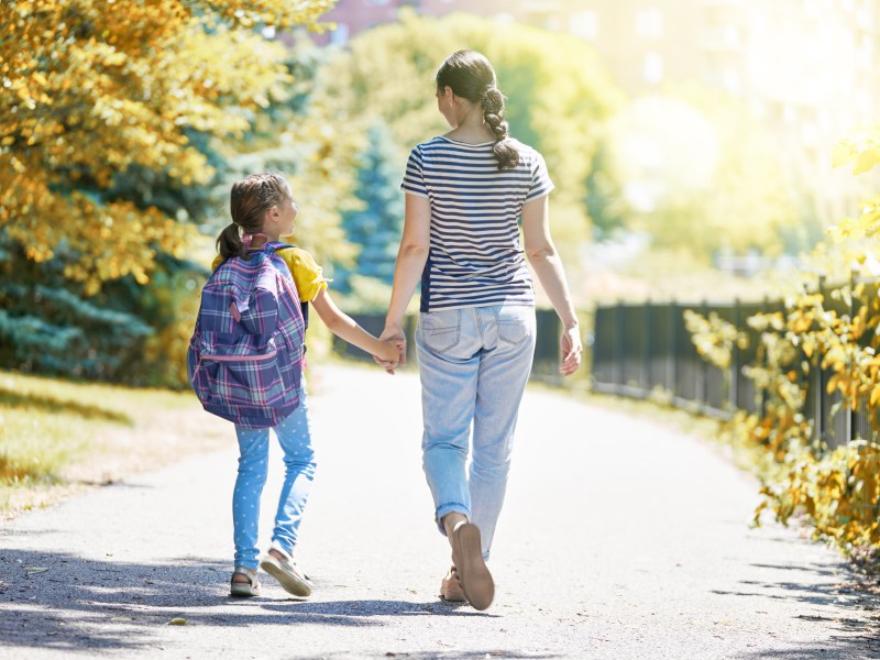 Eine Mutter hält die Hand ihrer kleinen Tochter.