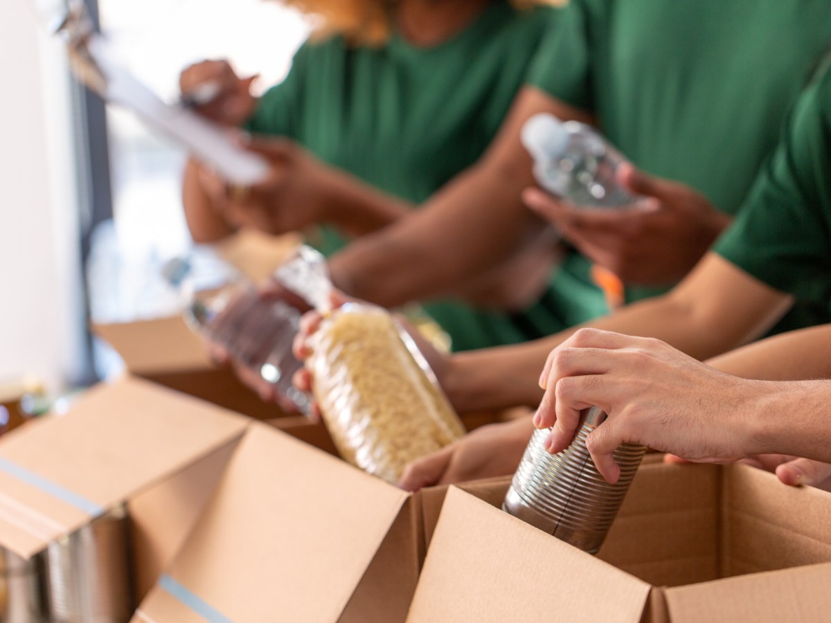 Personen packen Lebensmittel in Kartons.