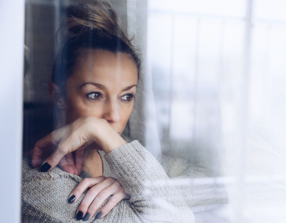 Frau mit Einsamkeit schaut aus dem Fenster